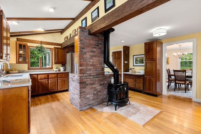 19 Birch St, Millis, MA 02054 - kitchen featuring a wood stove, light wood finished floors, light countertops, a chandelier, and brown cabinets