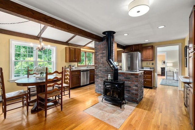 19 Birch St, Millis, MA 02054 - kitchen with appliances with stainless steel finishes, a wood stove, light wood-style flooring, light countertops, and beam ceiling