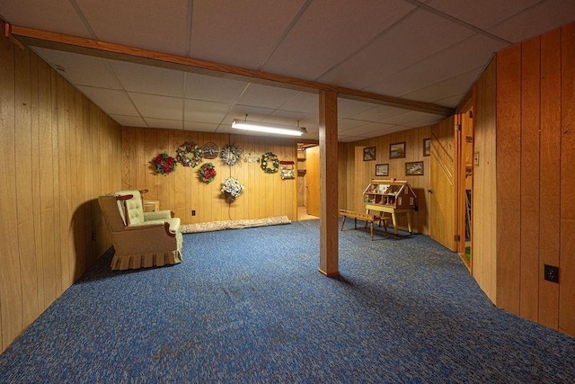 basement featuring carpet and wooden walls