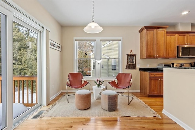 living area featuring light wood-type flooring, baseboards, and visible vents