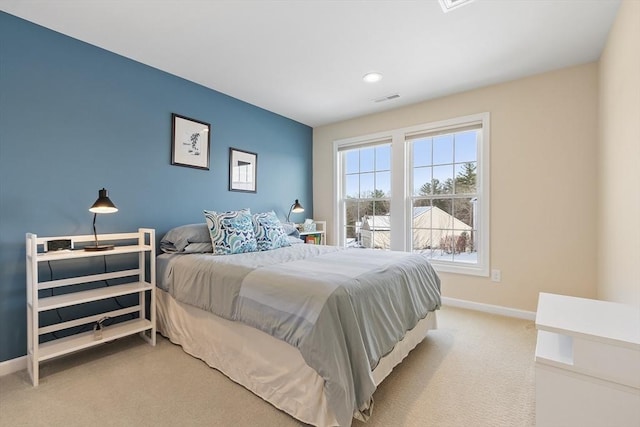 bedroom with light carpet, visible vents, and baseboards