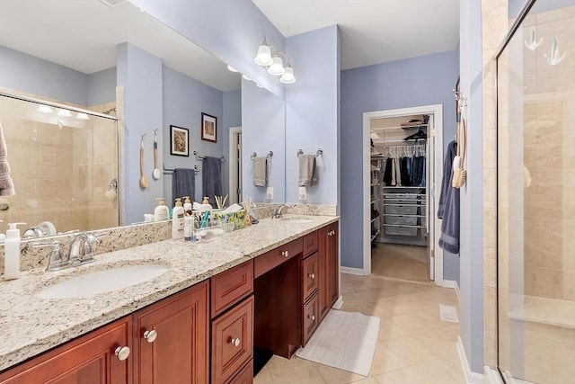 bathroom featuring a sink, a spacious closet, a shower stall, tile patterned floors, and double vanity