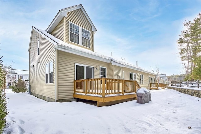 snow covered property with a wooden deck