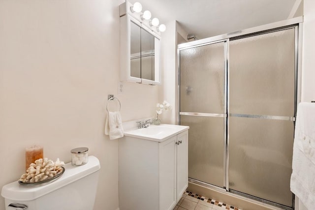 bathroom with toilet, tile patterned flooring, walk in shower, and vanity