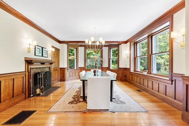 10 Eliot Rd, Lexington, MA 02421 - dining room with a wainscoted wall, ornamental molding, light wood-style flooring, a chandelier, and a fireplace with flush hearth