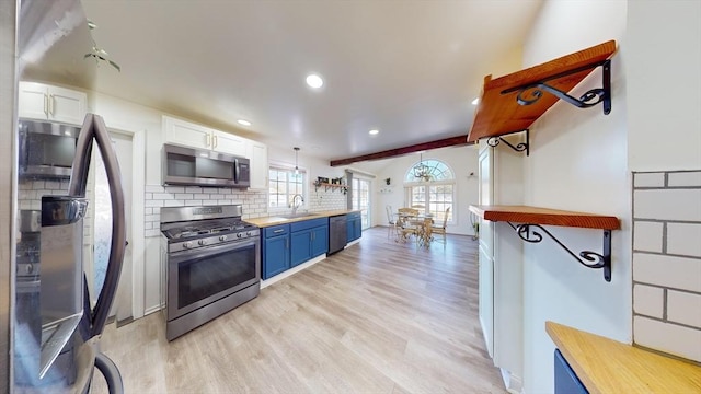 95 Prospect Street Ext, Westfield, MA 01085 - kitchen with white cabinets, blue cabinets, sink, light hardwood / wood-style floors, and stainless steel appliances
