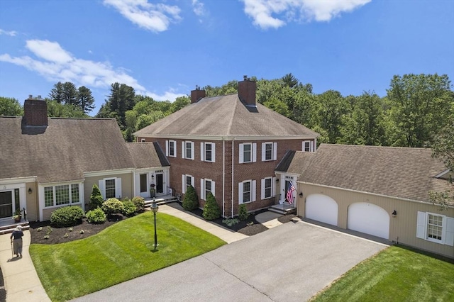 34 Martingale Unit 34, Andover, MA 01810 - view of front of property featuring a chimney, an attached garage, asphalt driveway, and a front lawn