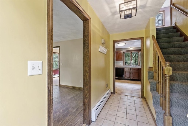 146 Lowell Rd, Pepperell, MA 01463 - hall featuring a baseboard heating unit, stairs, baseboard heating, and light tile patterned floors