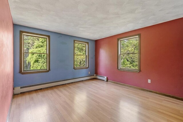 146 Lowell Rd, Pepperell, MA 01463 - empty room with a baseboard radiator, wood finished floors, and a textured ceiling
