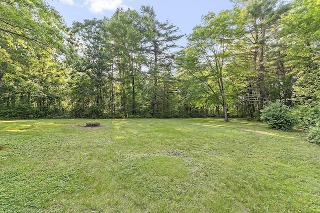 146 Lowell Rd, Pepperell, MA 01463 - view of grassy yard with an outdoor fire pit and a view of trees