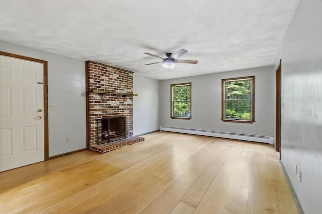 146 Lowell Rd, Pepperell, MA 01463 - unfurnished living room with a baseboard heating unit, a ceiling fan, a brick fireplace, and light wood-style floors