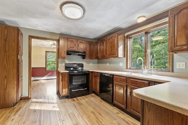 146 Lowell Rd, Pepperell, MA 01463 - kitchen featuring black appliances, a baseboard heating unit, light countertops, light wood finished floors, and under cabinet range hood