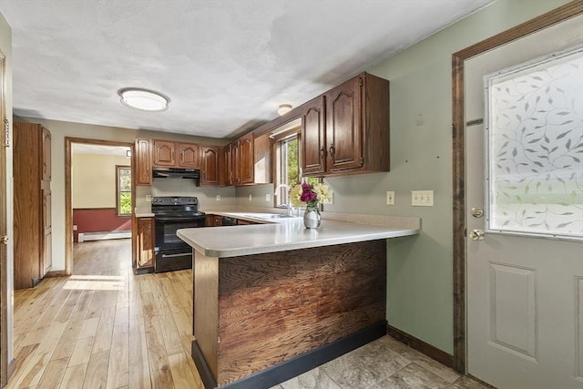 146 Lowell Rd, Pepperell, MA 01463 - kitchen with black electric range, under cabinet range hood, a baseboard heating unit, light countertops, and a peninsula