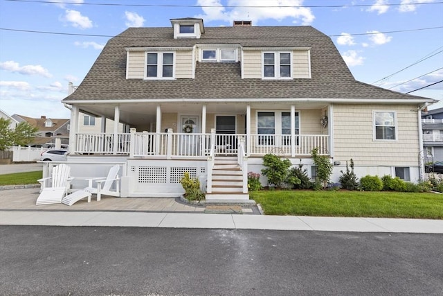 view of front of house with a shingled roof and covered porch