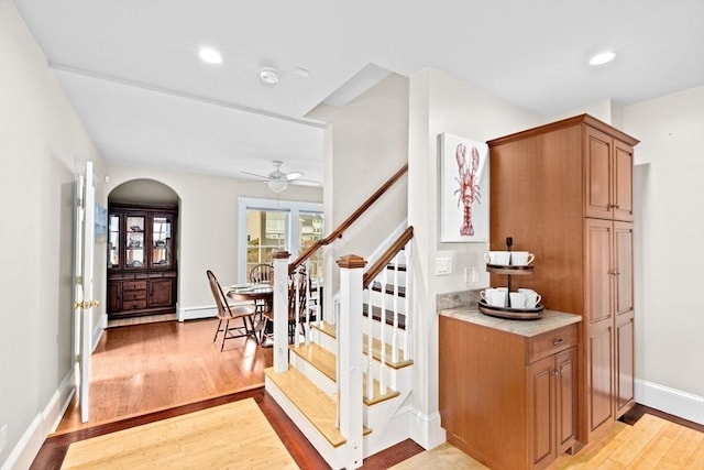 interior space featuring baseboards, a ceiling fan, wood finished floors, baseboard heating, and recessed lighting