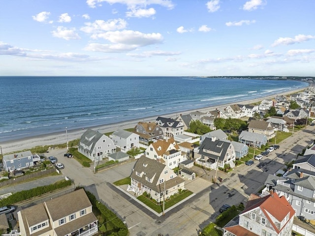 drone / aerial view featuring a view of the beach, a water view, and a residential view