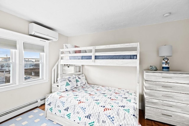 bedroom with a baseboard heating unit, wood finished floors, and a wall mounted AC