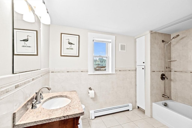 bathroom with tile walls, visible vents, baseboard heating, vanity, and shower / tub combination