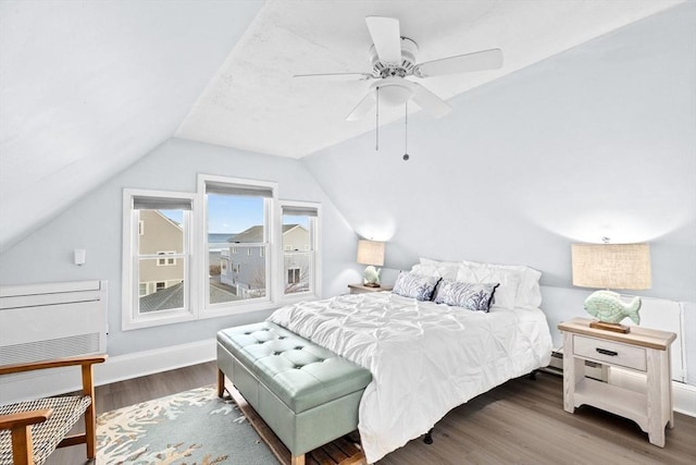 bedroom featuring a ceiling fan, vaulted ceiling, baseboards, and wood finished floors