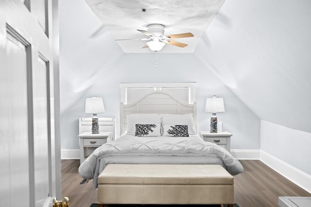 bedroom with vaulted ceiling, dark wood-style flooring, a textured ceiling, and baseboards