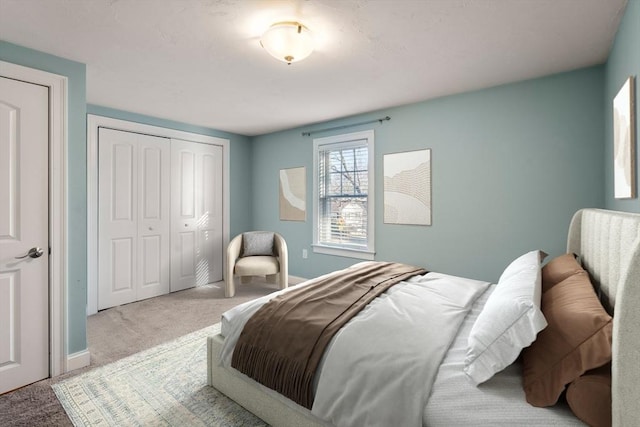 carpeted bedroom featuring baseboards and a closet