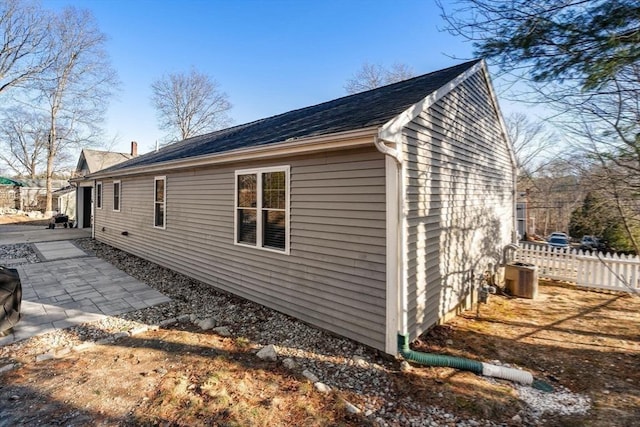 view of side of home with a patio, central AC unit, and fence