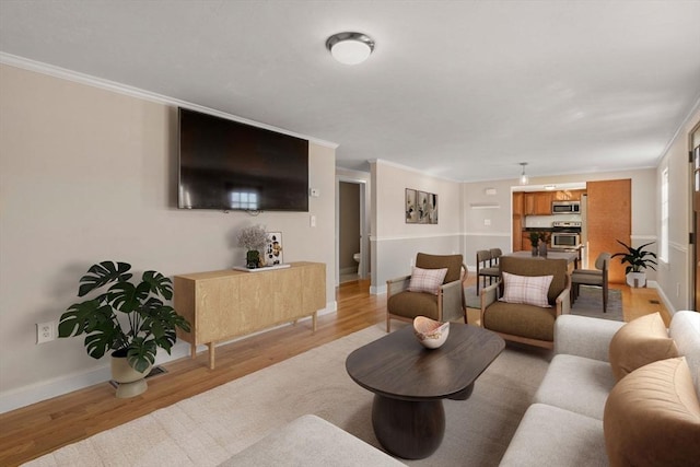 living area featuring light wood-type flooring, baseboards, and crown molding