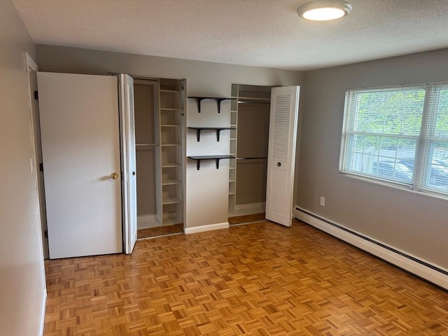 60A Washington Park Dr Unit 3, Andover, MA 01810 - unfurnished bedroom with baseboard heating, a textured ceiling, two closets, and baseboards