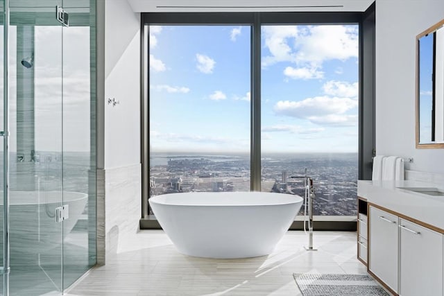 bathroom featuring vanity, independent shower and bath, and floor to ceiling windows