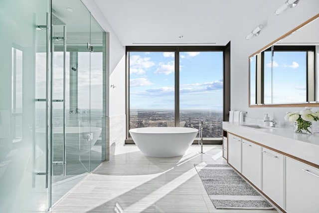 bathroom with tile patterned floors, expansive windows, vanity, and shower with separate bathtub