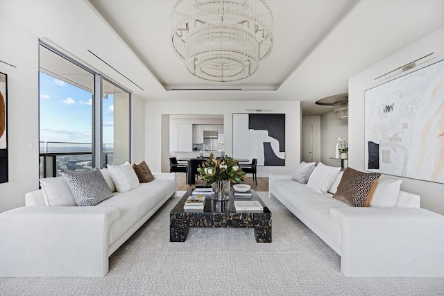 living room featuring a tray ceiling and an inviting chandelier