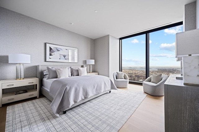 bedroom featuring expansive windows and light wood-type flooring