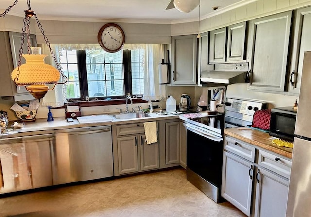 6 Damon Rd, Scituate, MA 02066 - kitchen with stainless steel appliances, under cabinet range hood, crown molding, a sink, and light countertops