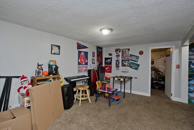 recreation room featuring a textured ceiling and carpet flooring