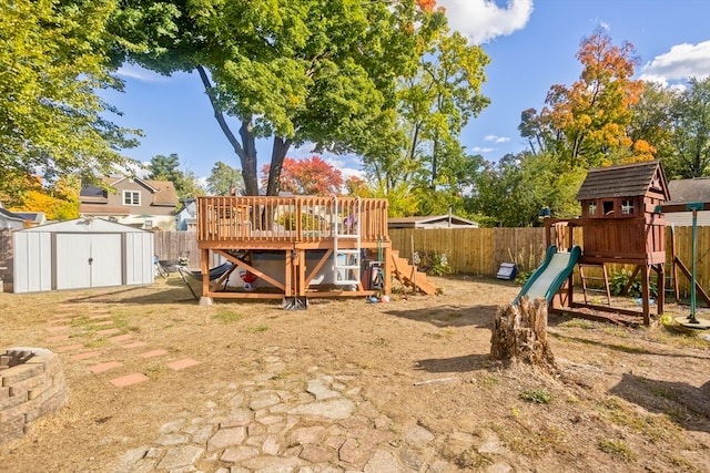 view of play area featuring a storage shed and a deck