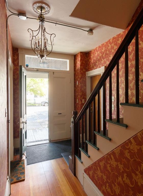 327 Lafayette St Unit 2, Salem, MA 01970 - entrance foyer with wallpapered walls, wood finished floors, stairs, and a chandelier