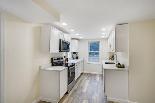 1030 Oak St, Dighton, MA 02764 - kitchen with appliances with stainless steel finishes, light countertops, light wood-style floors, recessed lighting, and white cabinets