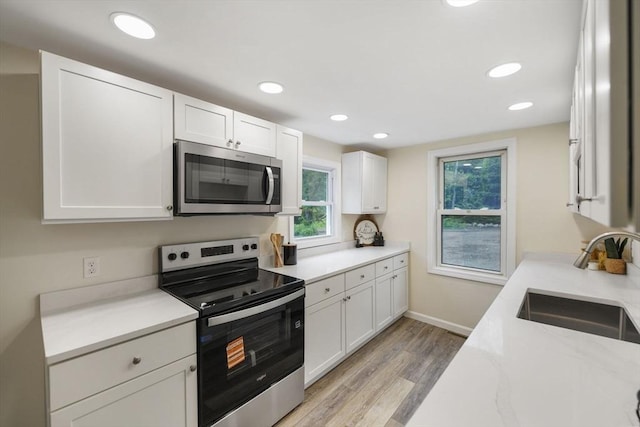 1030 Oak St, Dighton, MA 02764 - kitchen with appliances with stainless steel finishes, white cabinets, light wood-style floors, recessed lighting, and light stone countertops