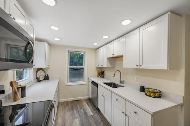 1030 Oak St, Dighton, MA 02764 - kitchen with appliances with stainless steel finishes, wood finished floors, white cabinetry, plenty of natural light, and recessed lighting