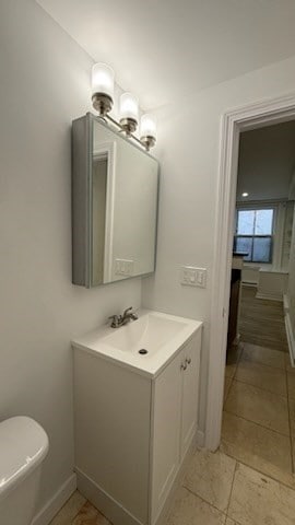 bathroom with toilet, vanity, and tile patterned floors