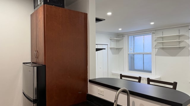 kitchen featuring white cabinetry and stainless steel fridge