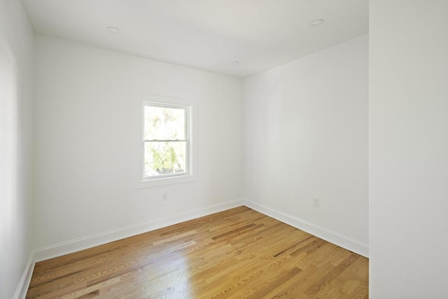 unfurnished room with baseboards and light wood finished floors