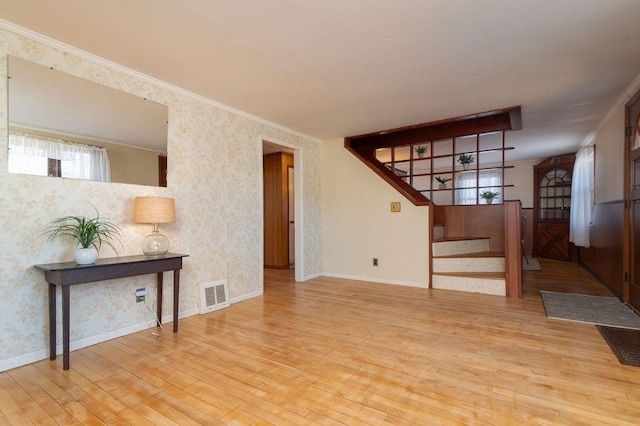 living room with a wealth of natural light, visible vents, stairs, and wallpapered walls