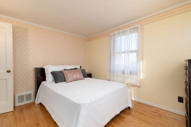 bedroom featuring wallpapered walls, crown molding, baseboards, and visible vents