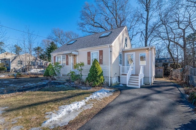 view of front of property featuring a shingled roof and fence