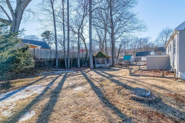 view of yard with a storage shed, an outdoor structure, and fence