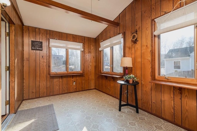 unfurnished sunroom with vaulted ceiling with beams