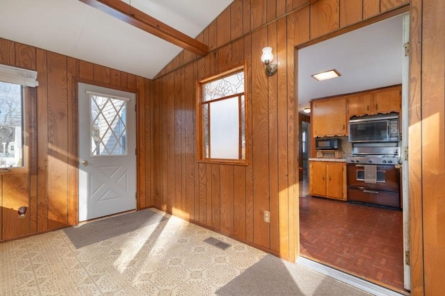 foyer entrance with baseboards, visible vents, lofted ceiling with beams, wood walls, and tile patterned floors