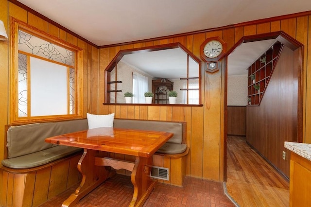 dining area with breakfast area, visible vents, arched walkways, and wooden walls