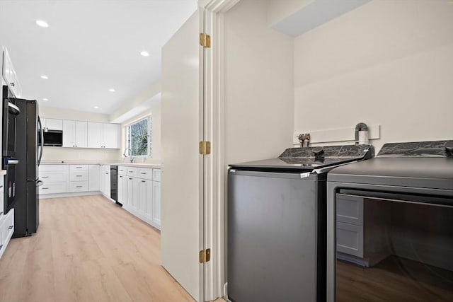 laundry area featuring washing machine and dryer, light wood-style floors, and recessed lighting